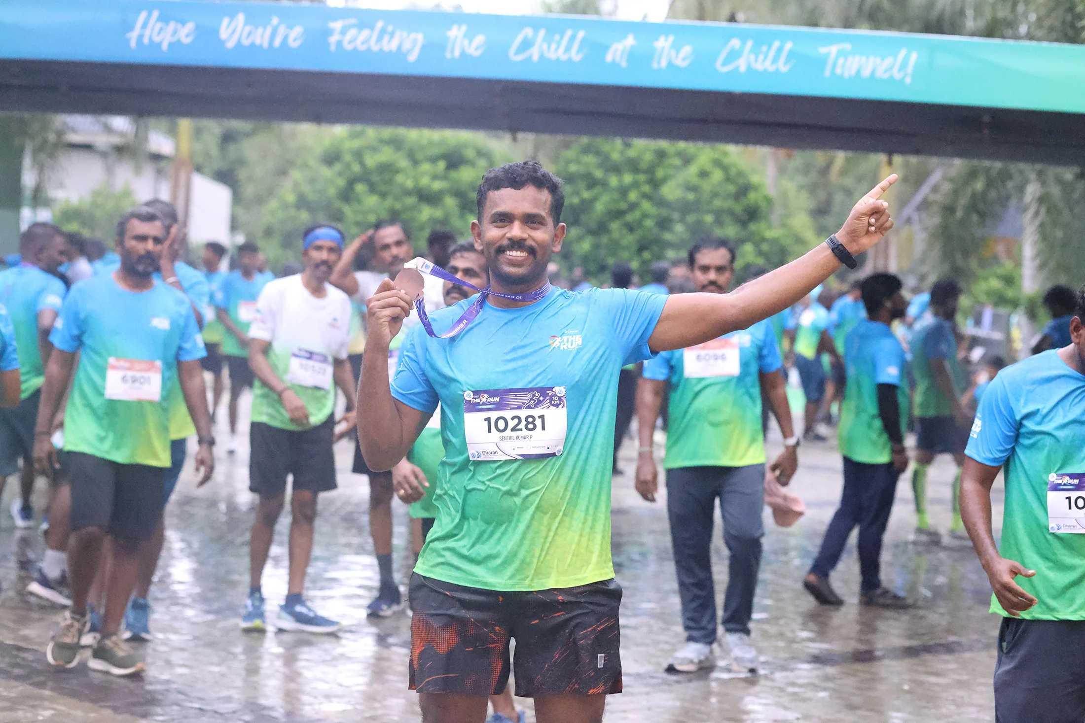 A smiling runner celebrating beneath the 2026 event signage.