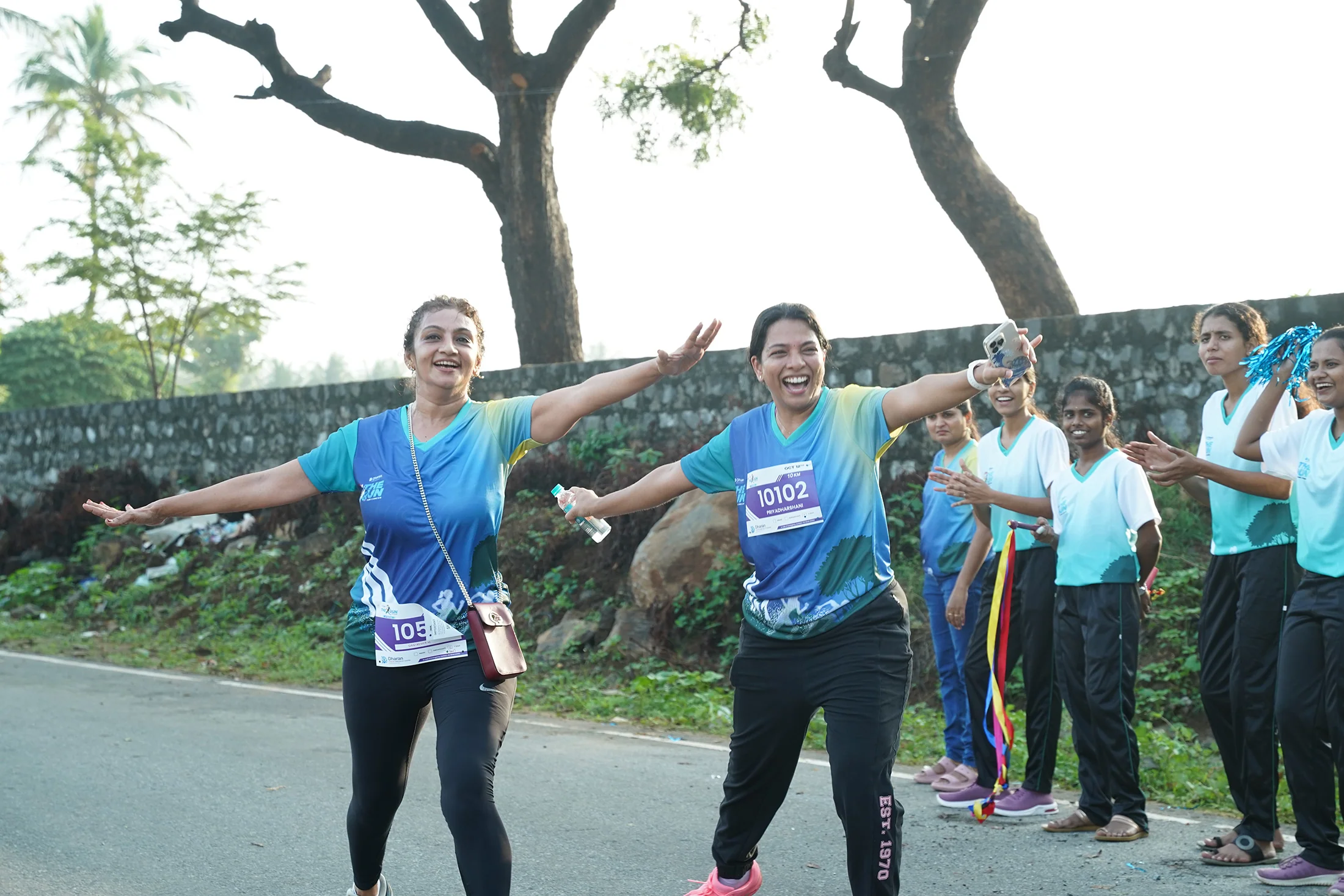 Two runners greeting volunteers beside the 2025 course.