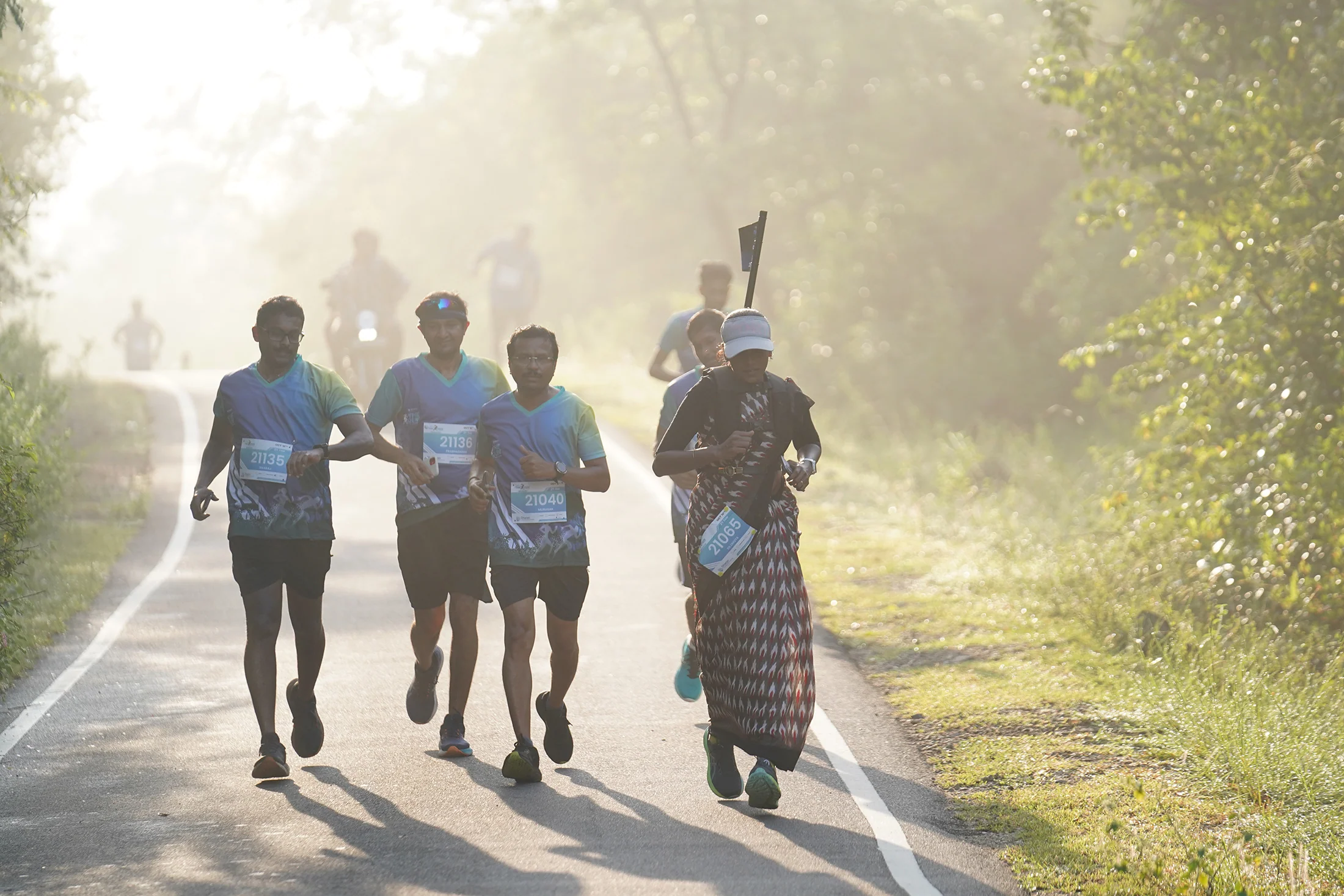 Three runners silhouetted by morning light on the 2025 course.