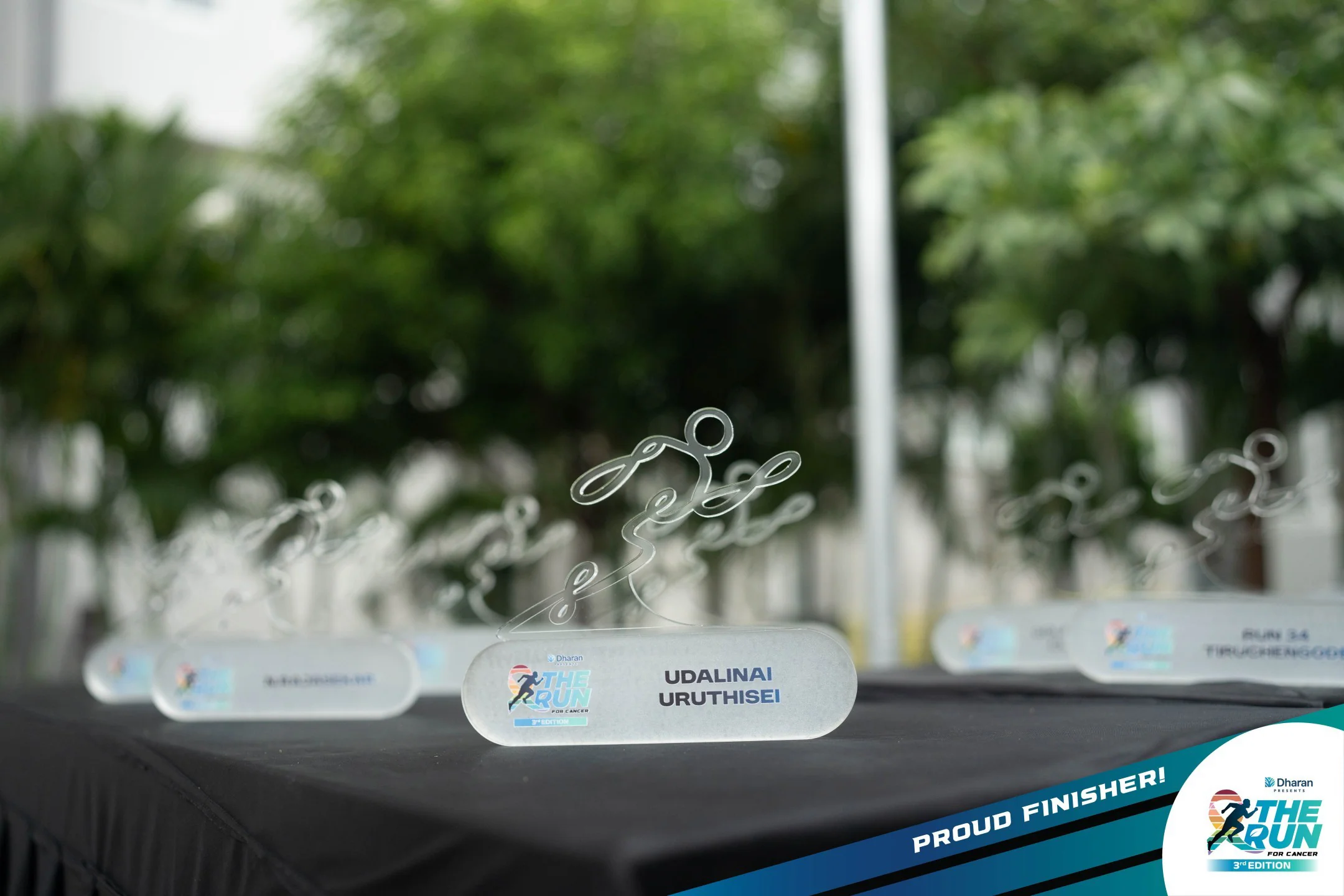 A finished 2026 memento with a clear runner outline and rounded base, photographed among the event-day awards.
