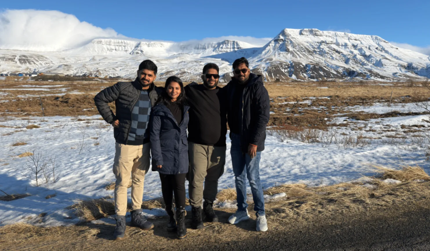 Roverland Voyage travellers with snow-capped Icelandic mountains behind
