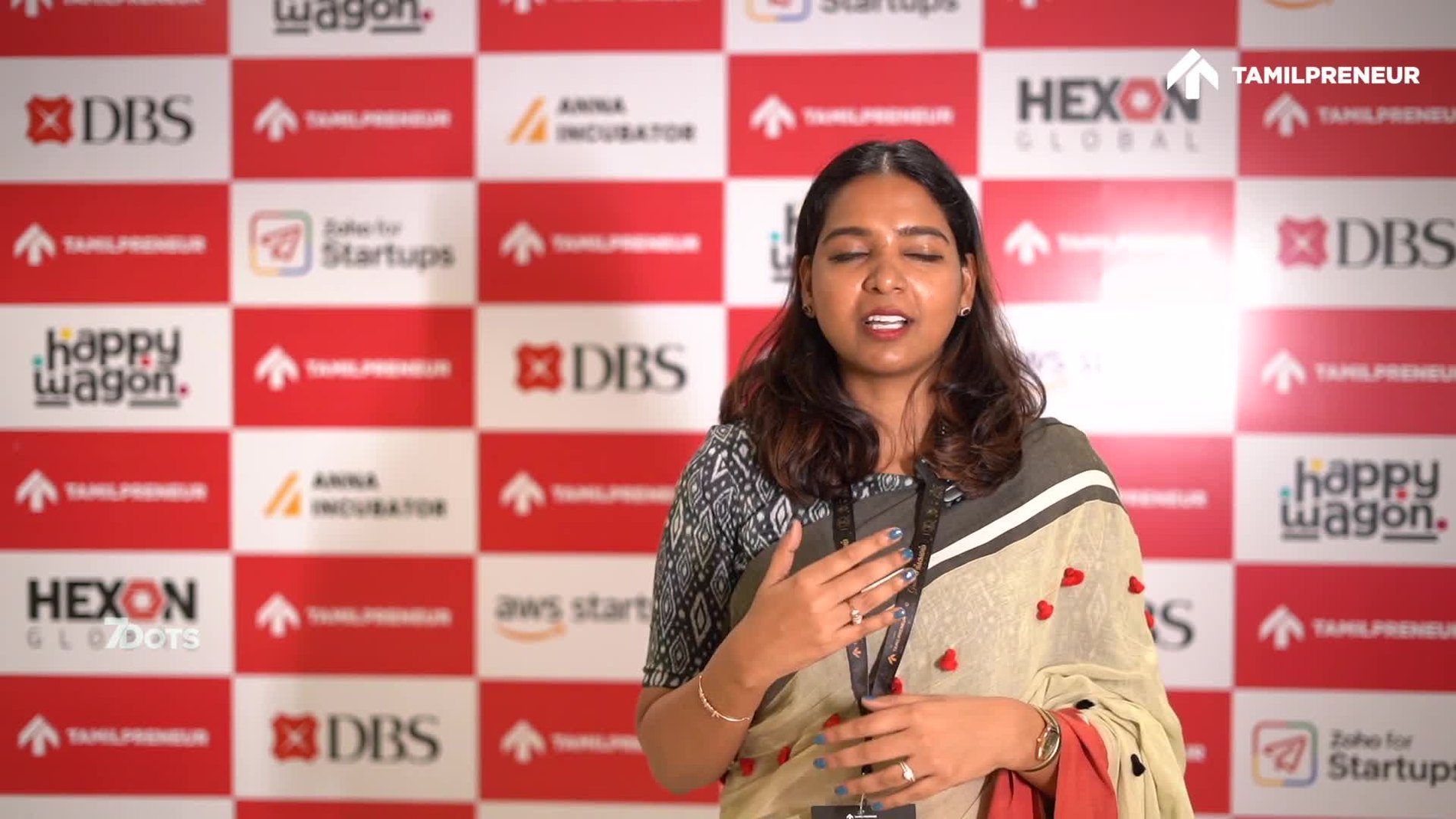 On stage, against the sponsor wall